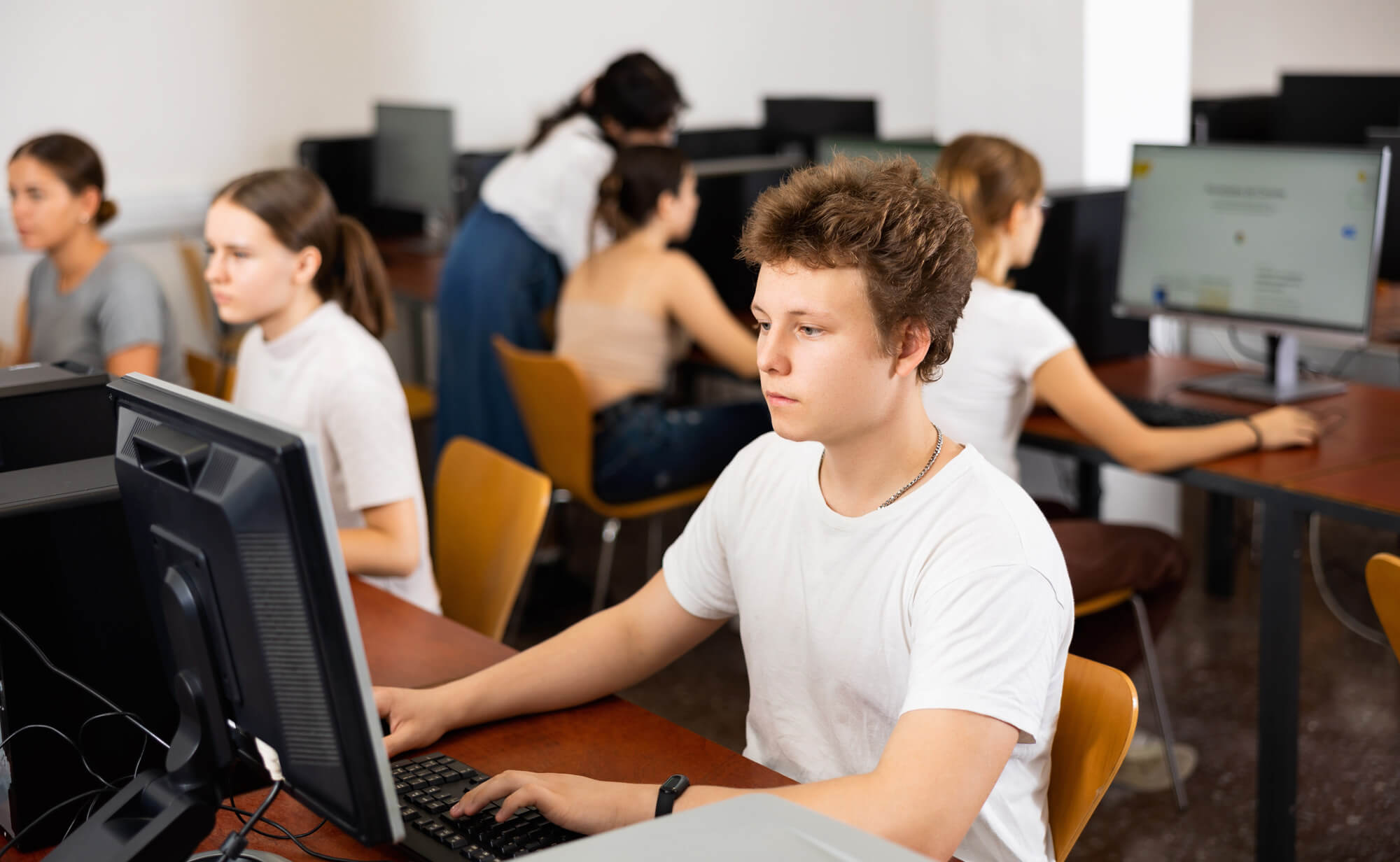 Students using desktop computers in a room.