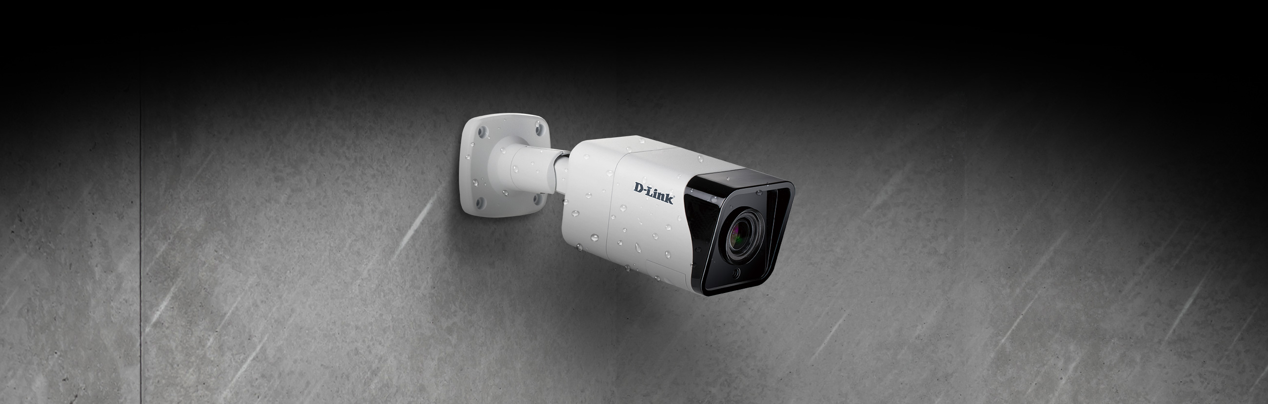 DCS-4718E 8 Megapixel H.265 Outdoor Bullet Camera mounted on a wall outside in the rain.