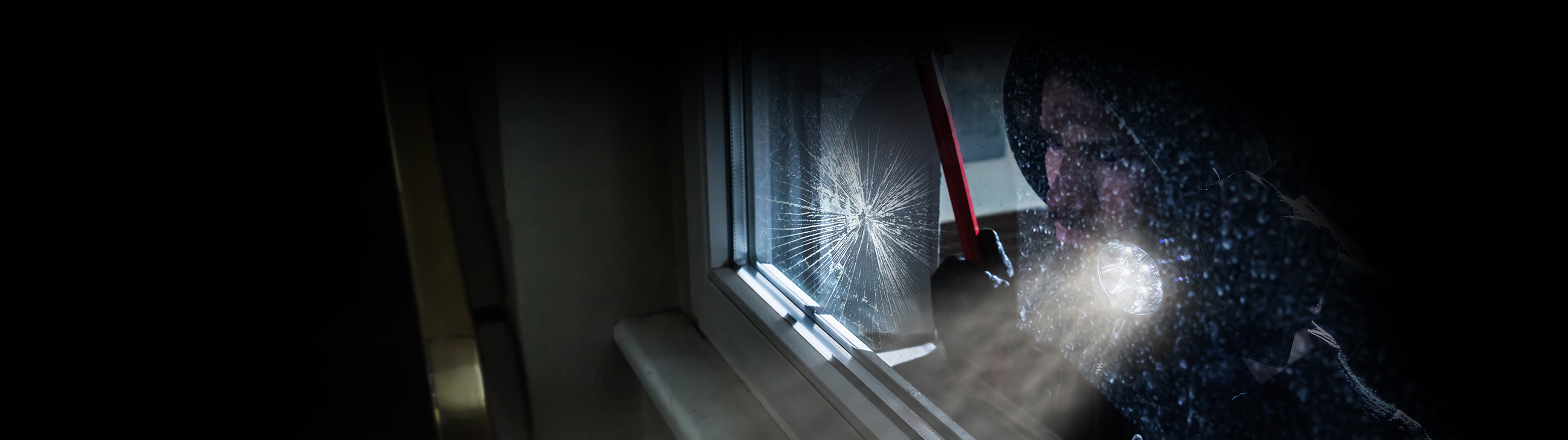 Intruder breaking glass window