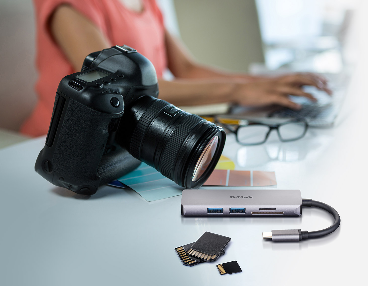 DUB-M530 5-in-1 USB-C Hub with HDMI/Card Reader next to a camera