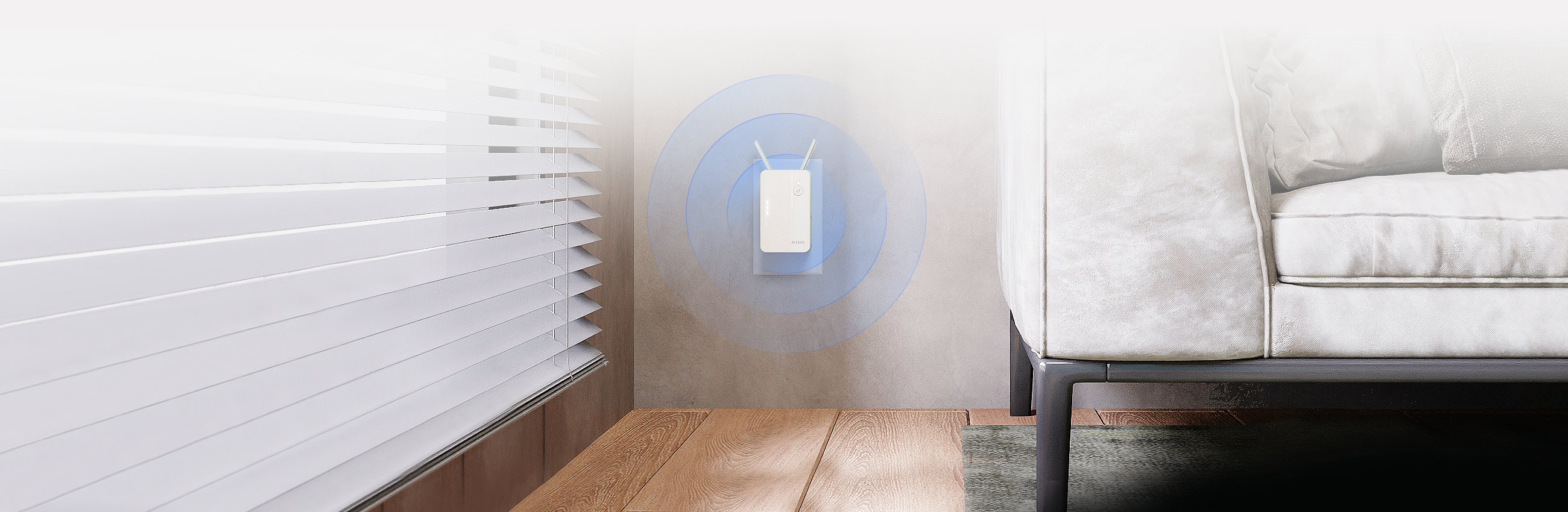 E15 AX1500 Mesh Range Extender plugged into an outlet next to a sofa.